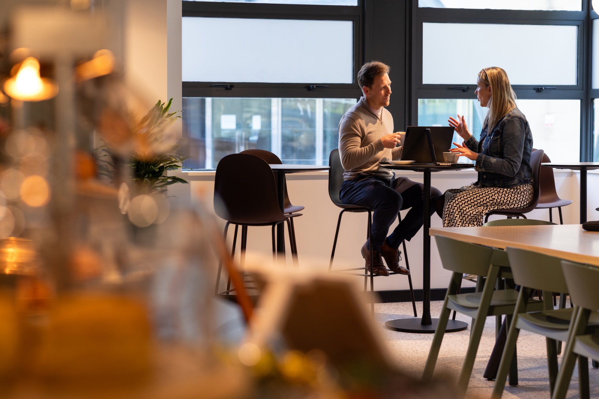 Two professionals in conversation in a modern workspace